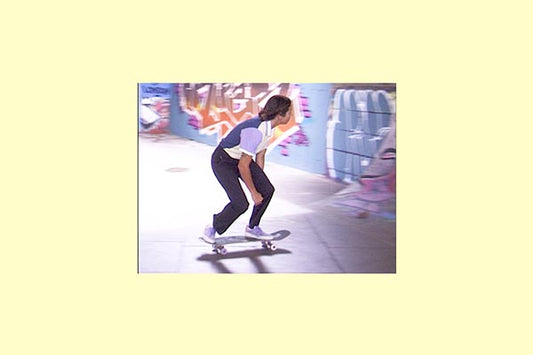 Nora Vasconcellos skating past a graffitied wall, shot on video with a pale yellow border, from the pam pam x adidas Skateboarding film