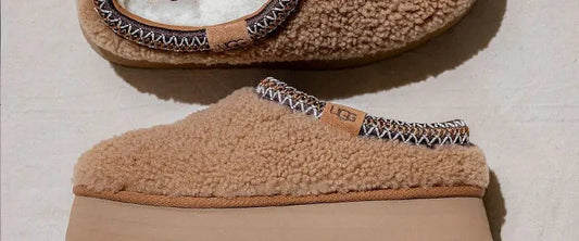 Tan UGG platform slippers with soft shearling upper and stitched trim, set on a chunky sole